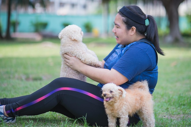 Jonge chinese vrouw die in openlucht hond houdt