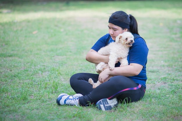 Jonge chinese vrouw die in openlucht hond houdt