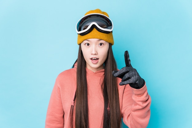 Jonge Chinese vrouw die skikleren draagt geïsoleerd hebbend een idee, inspiratieconcept.