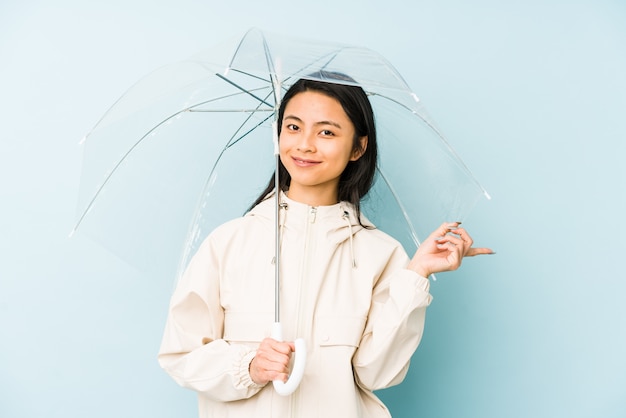Jonge chinese vrouw een paraplu houden die opzij richtend