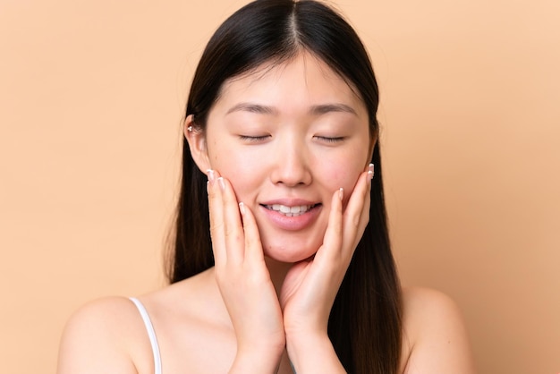 Jonge Chinese vrouw geïsoleerd op beige achtergrond Portret