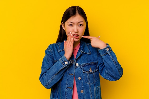 Jonge chinese vrouw geïsoleerd op geel met een sterke tandenpijn, kiespijn.