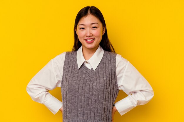 Jonge Chinese vrouw geïsoleerd op gele achtergrond gelukkig, lachend en vrolijk.