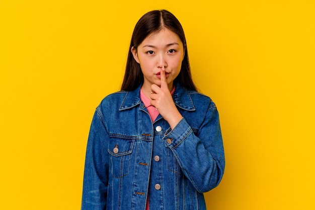 Jonge chinese vrouw geïsoleerd op gele muur denken en kijken, reflecterend zijn, overweegt, hebbend een fantasie