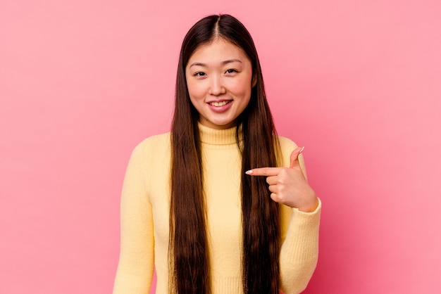 Jonge chinese vrouw geïsoleerd op roze achtergrond persoon met de hand wijzend naar een shirt kopie ruimte, trots en zelfverzekerd