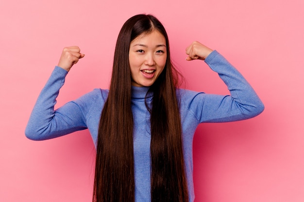 Jonge chinese vrouw geïsoleerd op roze muur zorgeloos en opgewonden toejuichen