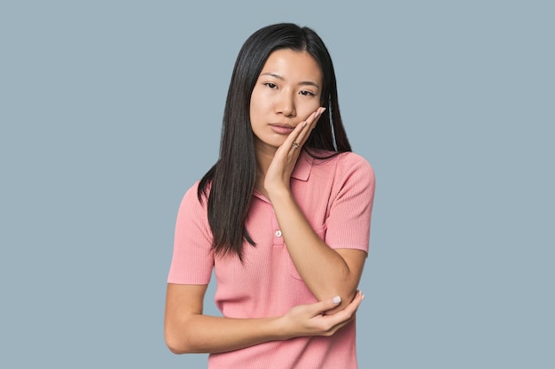 Jonge Chinese vrouw in een studio die zich verveelt, vermoeid is en een ontspannende dag nodig heeft.