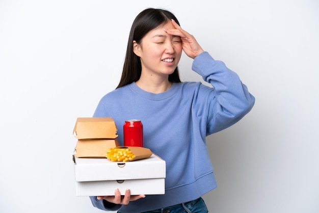 Jonge Chinese vrouw met fastfood geïsoleerd op een witte achtergrond lacht veel