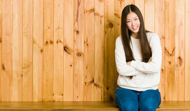 Jonge Chinese vrouwenzitting op een houten plaats die en pret lachen hebben.