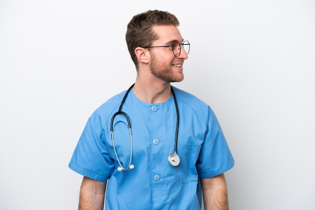 Jonge chirurg arts blanke man geïsoleerd op een witte achtergrond op zoek naar kant