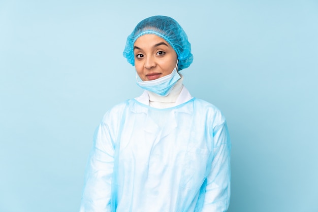 Jonge chirurg vrouw in blauw uniform lachen