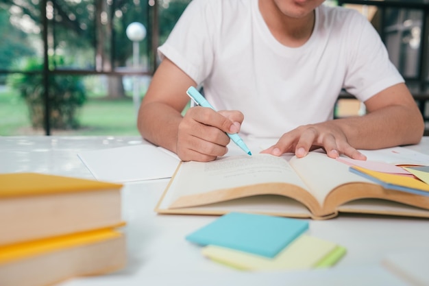 Jonge collagestudent die computer en mobiel apparaat gebruikt die online studeert Onderwijs en online leren