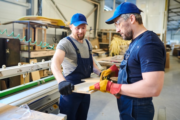 Jonge collega's die metingen van houten detail onderzoeken