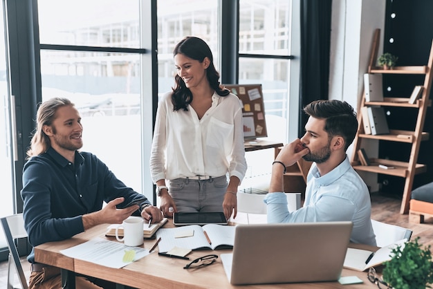 Jonge collega's. Jonge moderne collega's in slimme vrijetijdskleding die samenwerken en glimlachen