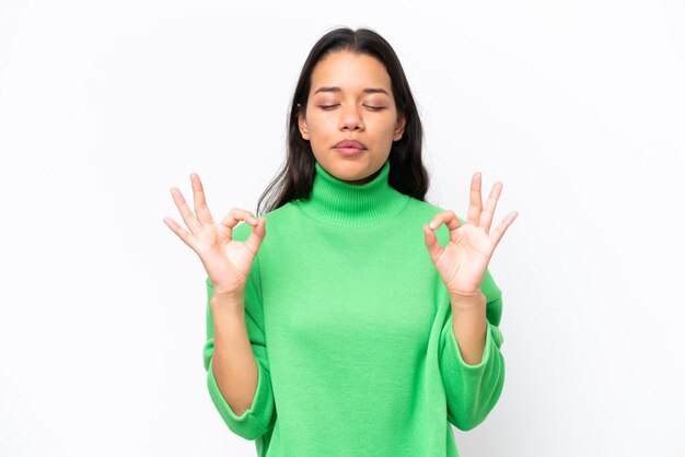 Jonge Colombiaanse vrouw geïsoleerd op een witte achtergrond in zen pose