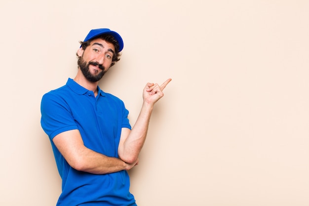 Jonge coole bebaarde man wijst naar de zijkant