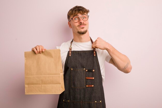 Jonge coole man die er arrogant uitziet, succesvolle positieve en trotse bezorger en fastfood