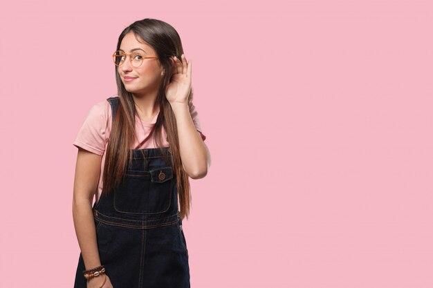 Jonge coole vrouw probeert te luisteren naar een roddel