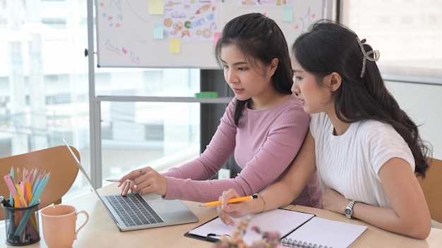 Jonge creatieve vrouw die ideeën deelt en online informatie bespreekt met collega's