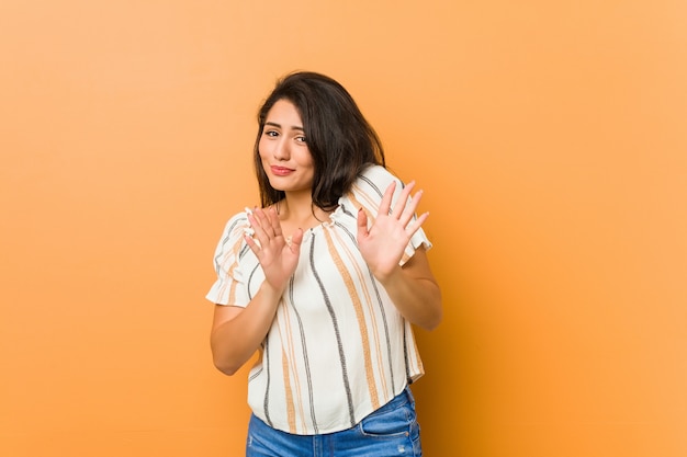 Jonge curvy vrouw die iemand verwerpt die een gebaar van afschuw toont.