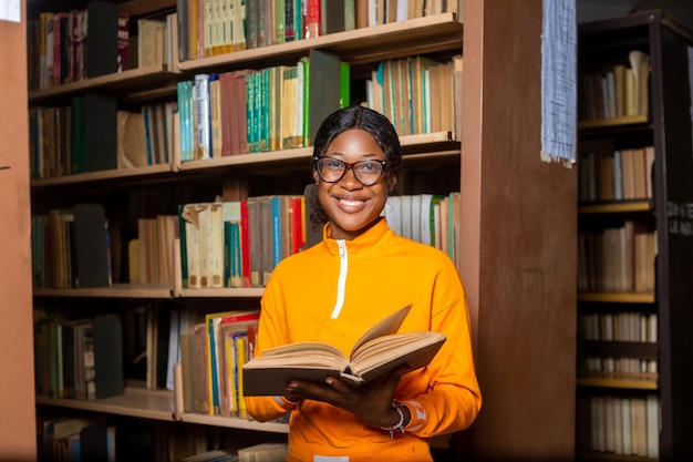 Jonge dame campus student in de bibliotheek lezen