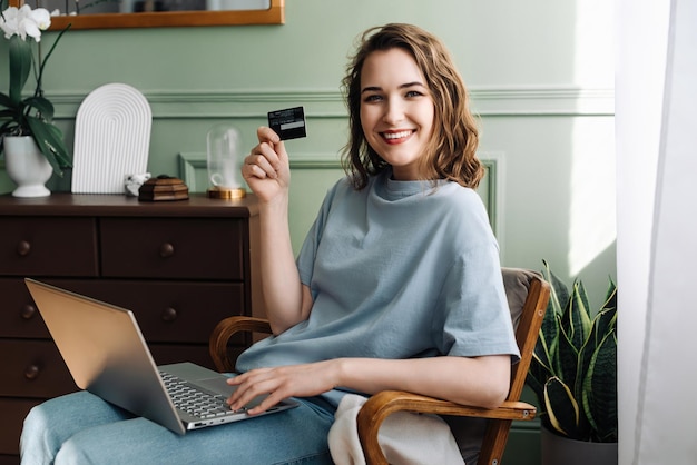 Jonge dame gebruikt enthousiast creditcard voor online aankopen E-commerce enthousiasme glimlachende vrouw Sho