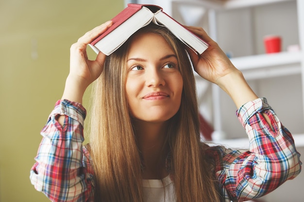 Jonge dame met boek boven haar hoofd