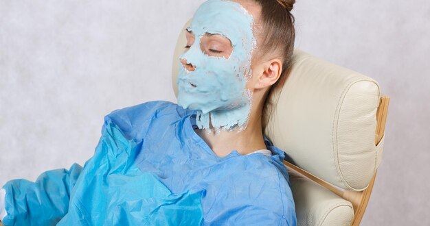 Foto jonge dame tussen de 30 en 40 jaar oud heeft een gezichtsmasker in een cosmetische fauteuil