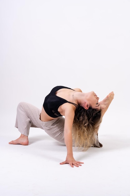 Jonge danseres in studio fotosessie met een witte achtergrond ballet dat zich uitstrekt op de vloer