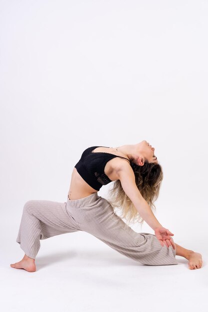 Jonge danseres in studio fotosessie met een witte achtergrond ballet uitvoeren van stretching