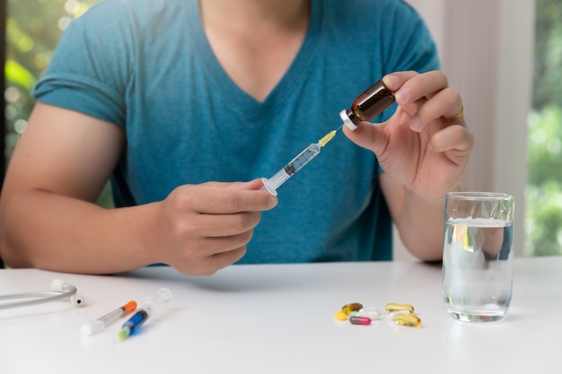 Jonge de injectienaald en het vaccin van de mensenholding ter beschikking