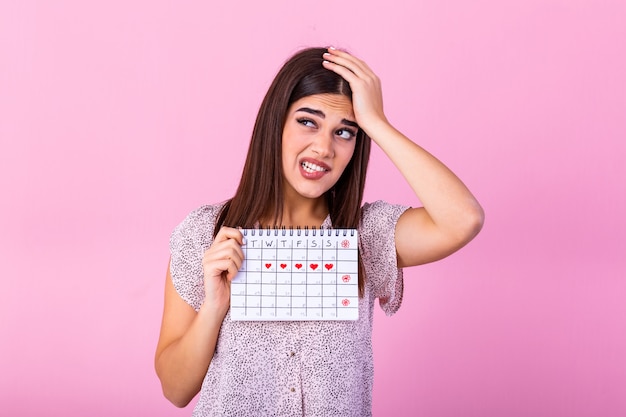 Jonge de menstruatiekalender van de vrouwenholding met verrassingsgezicht.