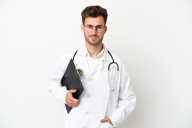 Jonge dokter blanke man over geïsoleerd op een witte achtergrond, gekleed in een doktersjas en met een map