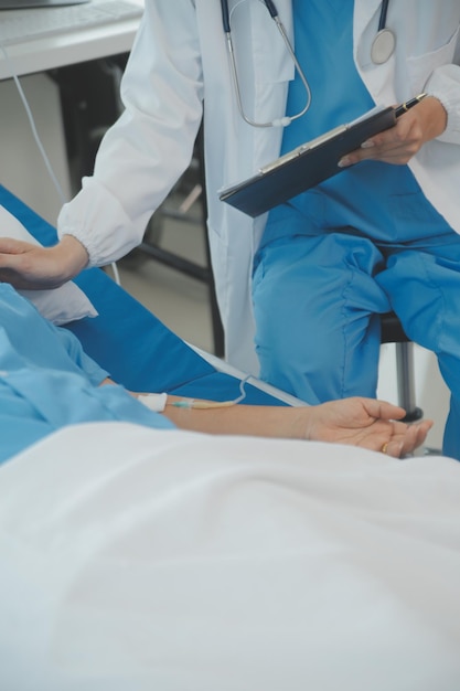 Jonge dokter gebruikt een stethoscoop luister naar de hartslag van de patiënt Shot van een vrouwelijke arts die een mannelijke patiënt een check-up geeft