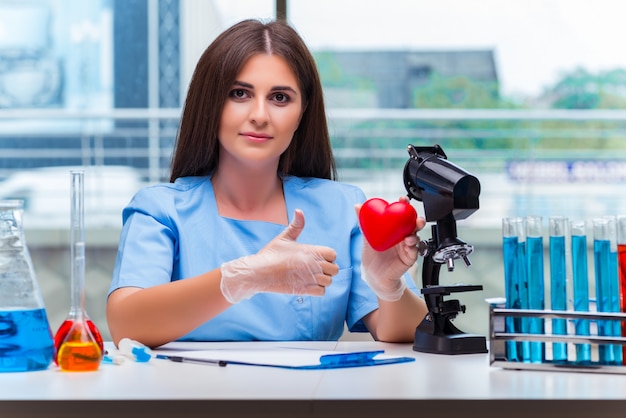 Jonge dokter met rood hart in het lab