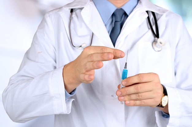 Jonge dokter met spuit in zijn hand