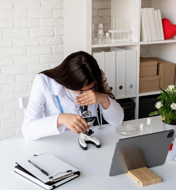 Jonge dokter of wetenschapper vrouw met behulp van microscoop