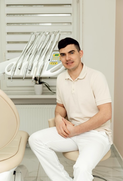 Jonge dokter tandarts is in de tandartspraktijk hooggekwalificeerde tandarts portret van een arts op de werkplek tandartspraktijk