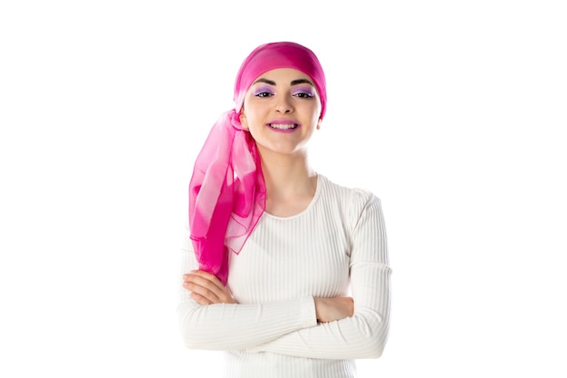Jonge donkerbruine vrouw die roze geïsoleerde hoofddoek draagt
