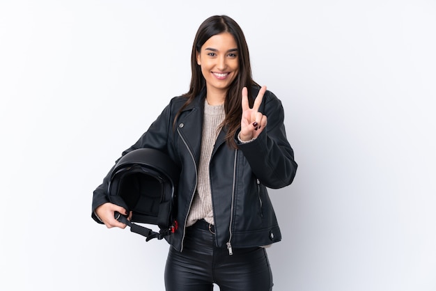Jonge donkerbruine vrouw met een motorhelm die en overwinningsteken glimlacht toont