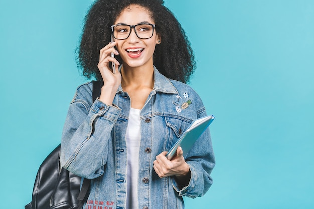 Foto jonge donkerbruine vrouw met notitieboekje en telefoon