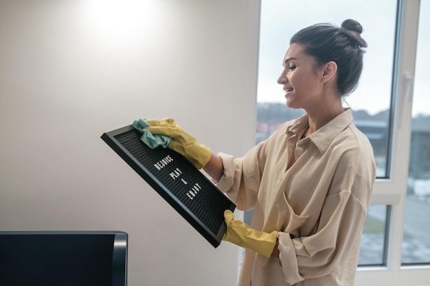 Jonge donkerharige vrouw die het scherm schoonmaakt