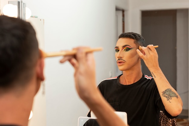 Jonge drag queen artiest doet haar make-up in de kleedkamer