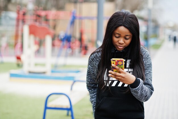 Jonge duizendjarige Afro-Amerikaanse meisje in de stad Gelukkig zwarte vrouw met mobiele telefoon Generation Z concept