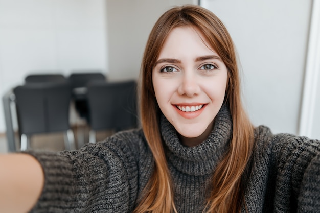 Foto jonge duizendjarige mooie vrouw die selfie thuis in flat maken