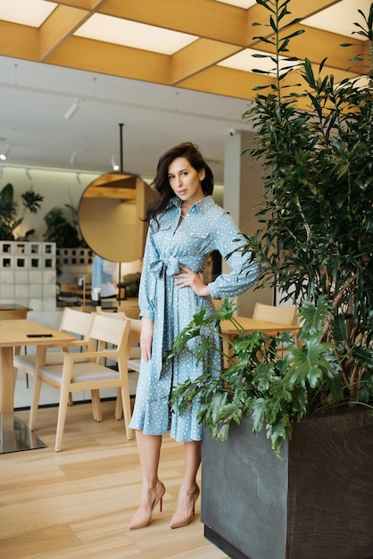 Jonge elegante meid die zich voordeed binnen Vrij mooie zakenvrouw in elegante jurk aan de muur