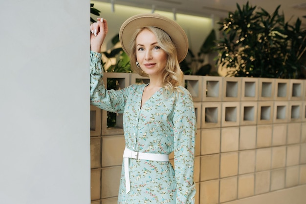 Jonge elegante meid die zich voordeed binnen Vrij mooie zakenvrouw in elegante jurk aan de muur