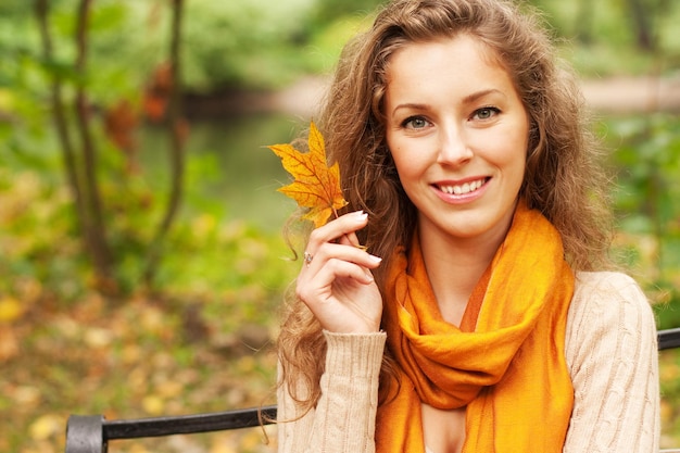 Jonge elegante vrouw met herfstbladeren