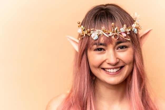 Jonge elf vrouw met roze haar geïsoleerd op beige background