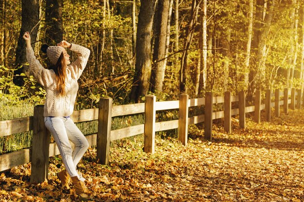 Jonge en gelukkige vrouw in het park op zonnige herfstdag